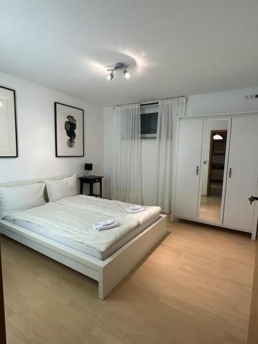 a white bedroom with a large white bed in it at Gemütliche Ferienwohnung in Wolfhagen mit Terrasse in Wolfhagen