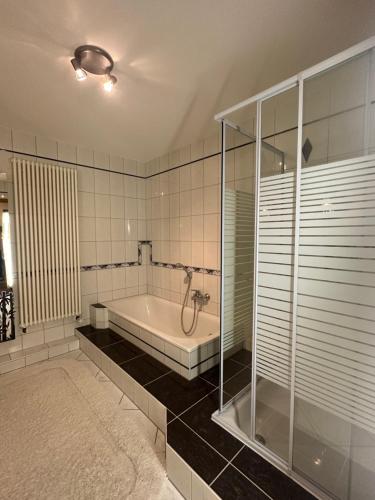 La grande salle de bains est pourvue d'une baignoire et d'une douche. dans l'établissement Gemütliche Ferienwohnung in Wolfhagen mit Terrasse, à Wolfhagen