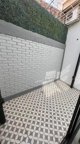 uma parede de tijolos brancos com piso em azulejo na frente em Jameli house em Mendoza
