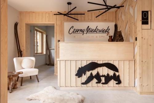 コシチェリスコにあるRezydencja & SPA Czarny Niedźwiedźのリビングルーム(熊の看板付)