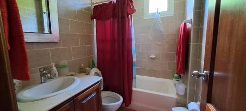 a bathroom with a sink and a red shower curtain at Goistay Oasis Juan Dolio,escapada Sonada Te Espera in Paraíso