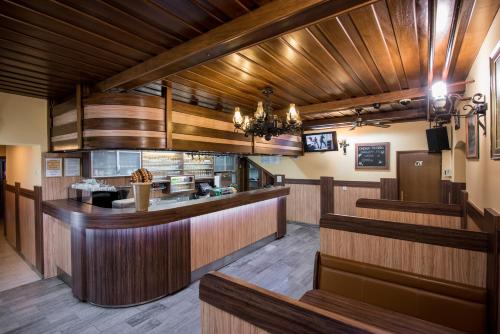 a restaurant with wood paneling and a kitchen with a counter at Gostisce Ulipi in Slovenske Konjice