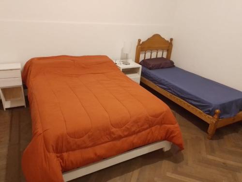 a bedroom with two twin beds and a nightstand and a bedskirts at San Telmo Hostel in Buenos Aires