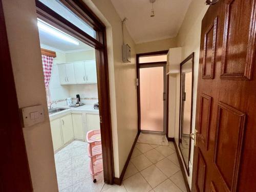a kitchen with a door open to a room with a sink at Charming Retreat in Garden Estate-Thome, Thika Rd in Nairobi