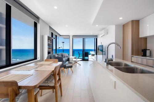 a kitchen with a table and a view of the ocean at Ocean Views Apartment with Rooftop Pool - CoastHM in Gold Coast