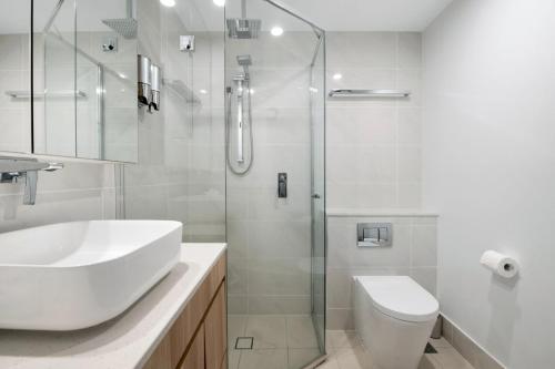 a bathroom with a sink and a toilet and a shower at Ocean Views Apartment with Rooftop Pool - CoastHM in Gold Coast