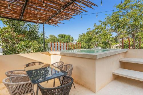 an outdoor bar with chairs and a table and a table and chairsktop at Stunning 4br - Rooftop Pool, 5 mins to beach in Tulum