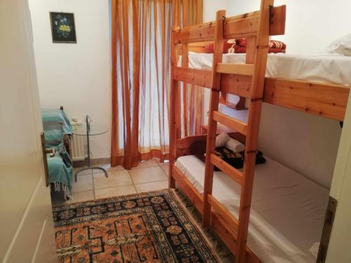 a bedroom with two bunk beds and a rug at Villa afroditi in Pefkohori