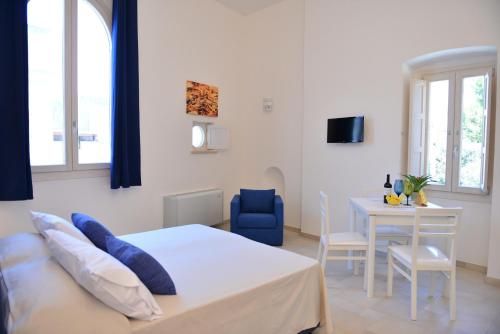 a bedroom with a bed and a table with a blue chair at Tobacco Suite in Mesagne