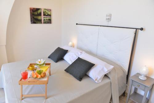 a white bed with a tray of fruit on it at Tobacco Suite in Mesagne
