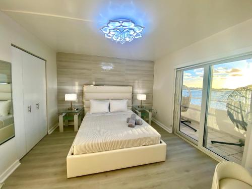 a bedroom with a large bed and a chandelier at Panoramic luxurious waterfront one bedroom apartment with Miami skyline view Free parking 5min drive to Miami Beach in Miami Beach