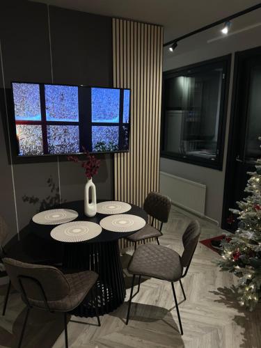 a dining room with a table and chairs and a christmas tree at modern studio @ city center in Rovaniemi