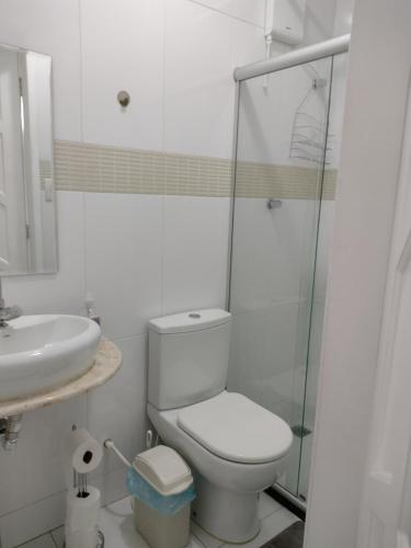 a white bathroom with a toilet and a sink at Fantástico in Santo Amaro