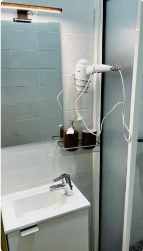 baño con lavabo y secador de pelo junto a un espejo en Apartamento Alfama - Lisbon en Lisboa