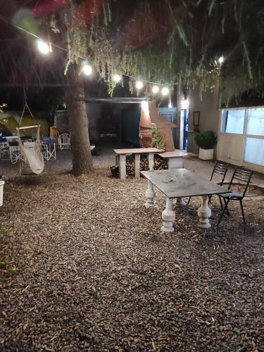 - une table de pique-nique et un banc dans une cour la nuit dans l'établissement Espacio arcevia, à Caseros