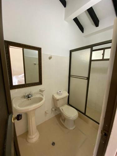 a bathroom with a toilet and a sink and a mirror at Hacienda La Pola in Guaduas