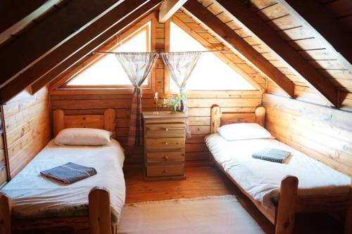 two beds in a room in a log cabin at Estancia La Esperanza in San Carlos de Bariloche