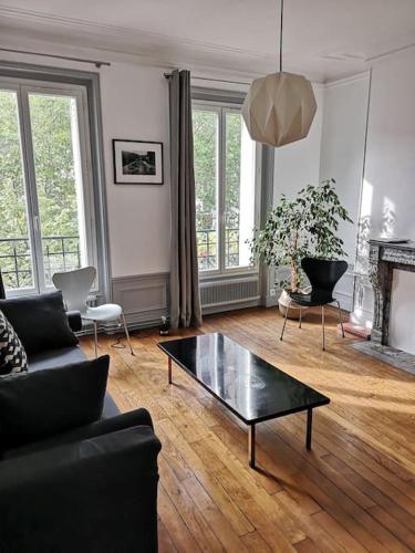 ein Wohnzimmer mit einem Sofa und einem Couchtisch in der Unterkunft Lumineux,chic, appartement Haussmannien de 50 m2 in Clichy