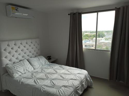 sypialnia z łóżkiem i dużym oknem w obiekcie Hermoso apartamento frente al mar w mieście Ríohacha