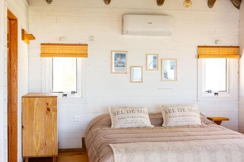 a bedroom with a bed with two pillows on it at Cabaña Agua de Mar in Punta Del Diablo