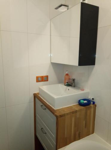 une salle de bain avec un lavabo blanc et un miroir dans l'établissement Chambre avec balcon - Parc des Expos Porte de Versailles, à Vanves