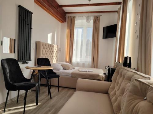 a living room with a bed and a table and chairs at Parkowy Kudowa in Kudowa-Zdrój