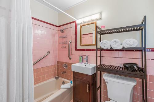 une salle de bains rose avec lavabo et toilettes. dans l'établissement 3 Bd House, Walkable To Bart, Free Parking, Views, à Daly City