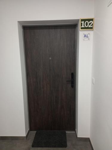 a wooden door in a building with a sign on it at Garden House Fundão - Estúdio 102 com vista jardim in Fundão
