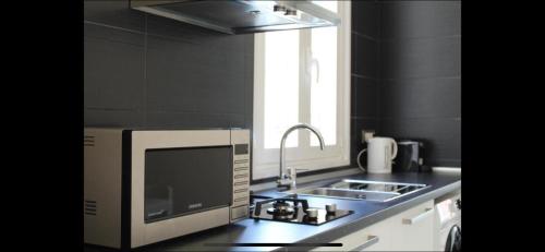 una cucina con lavandino e forno a microonde di Angel Room Nel Corso a Cagliari