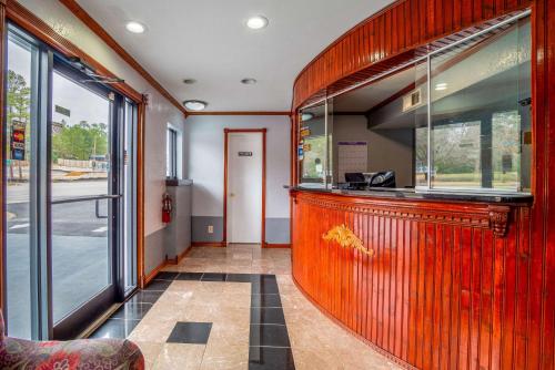 a restaurant with a wooden bar in a building at Rodeway Inn & Suites Fort Jackson in Columbia