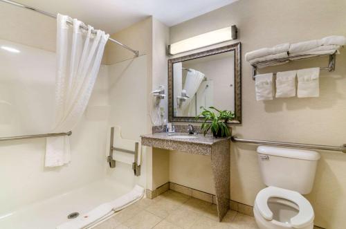 a bathroom with a toilet and a sink and a tub at Comfort Inn & Suites near Bethel College in Newton