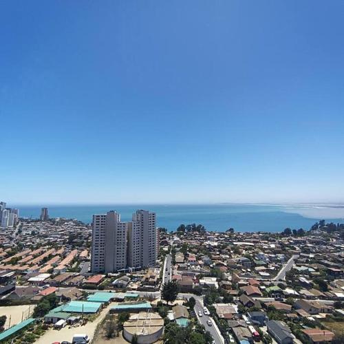 an aerial view of a city with buildings and the ocean at Lindo y acogedor departamento. in Concón