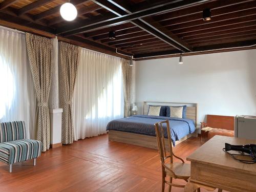 Ban Mae Cho的住宿－บ้านวิวนา Baan View Na，卧室配有一张床和一张桌子及椅子