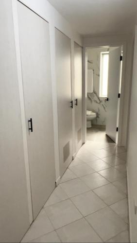 a hallway with white doors and a white tile floor at Cimarron Suites Playa Parguito in Aricagua