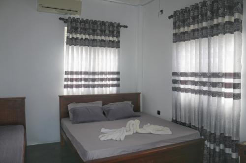1 dormitorio con 1 cama con 2 toallas en Dinuli home stay, en Ahungalla