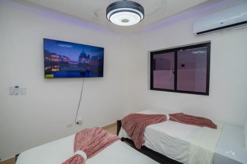 een slaapkamer met een bed en een foto aan de muur bij villa green paradise in San Felipe de Puerto Plata