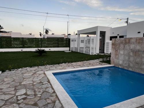 een zwembad in een tuin naast een huis bij villa green paradise in San Felipe de Puerto Plata