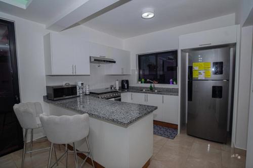 a kitchen with a counter and a refrigerator at villa green paradise in San Felipe de Puerto Plata