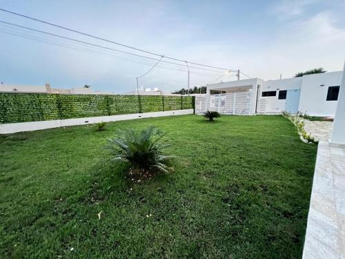 a backyard with a fence and a grass yard at villa green paradise in San Felipe de Puerto Plata