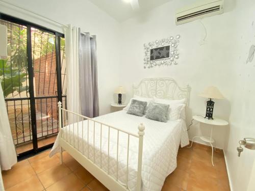 Habitación blanca con cama y balcón. en ZONA COLONIAL 2 habitaciones+wifi+balcon apartamento completo, en Santo Domingo