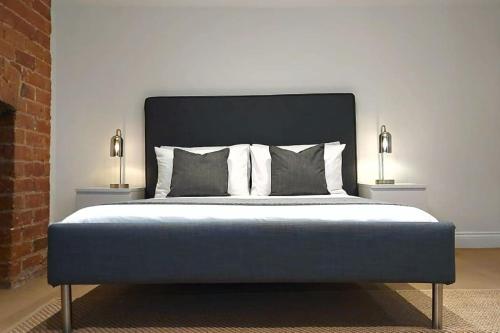 a bedroom with a bed with two lamps on both sides at 2 Bedroom City Centre Duplex Apt in Preston