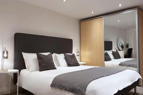 1 dormitorio con 2 camas y un espejo grande en 2 Bedroom City Centre Duplex Apt, en Preston