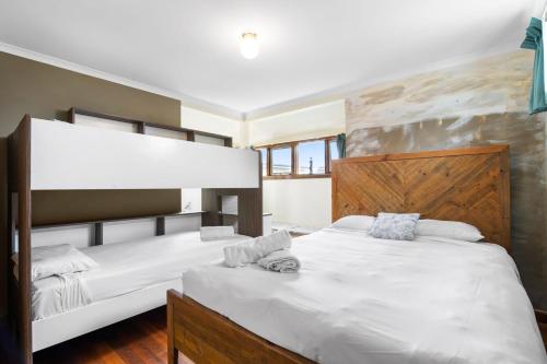 um quarto com 2 camas e lençóis brancos em Price on the Beach 2c em Torquay
