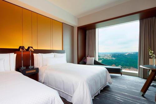 a hotel room with two beds and a large window at The Westin Sendai in Sendai