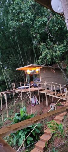 una terraza de madera con mesa y sombrilla en Kuyana Glamping, en Cali