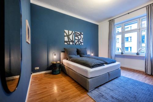 a bedroom with a bed and a blue wall at Südstadt-Oase Komfort mit 2 SZ und Balkon in Koblenz