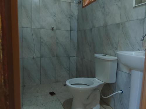 a bathroom with a toilet and a sink at Suítes Recanto Dos Passarinhos 2 in Ubatuba