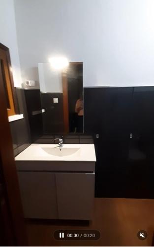 a bathroom with a sink and a mirror at Casinha Ponte Nova in Monção