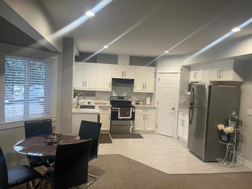 a kitchen with a table and a refrigerator at 2 Bedroom Suite with Full Kitchen ( Sweet Home Rental) in Revelstoke