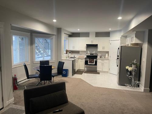 a kitchen with a refrigerator and a table and chairs at 2 Bedroom Suite with Full Kitchen ( Sweet Home Rental) in Revelstoke